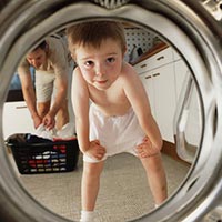 Kind schaut in Waschmaschine